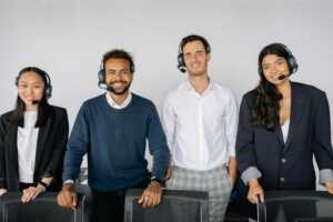 A diverse group of customer service representatives wearing headsets in a modern office.